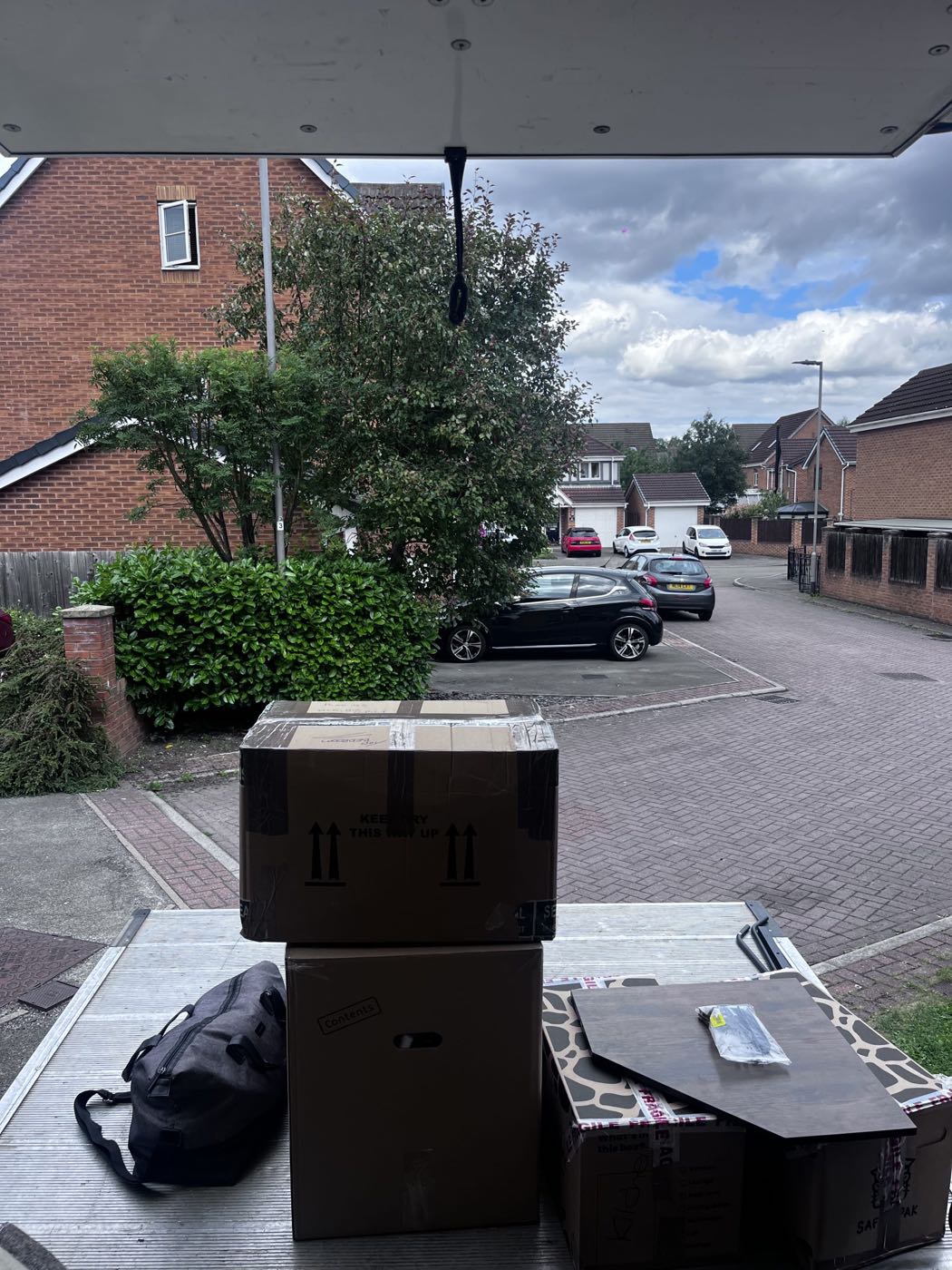 Packed and labelled boxes stacked on a driveway ready to load