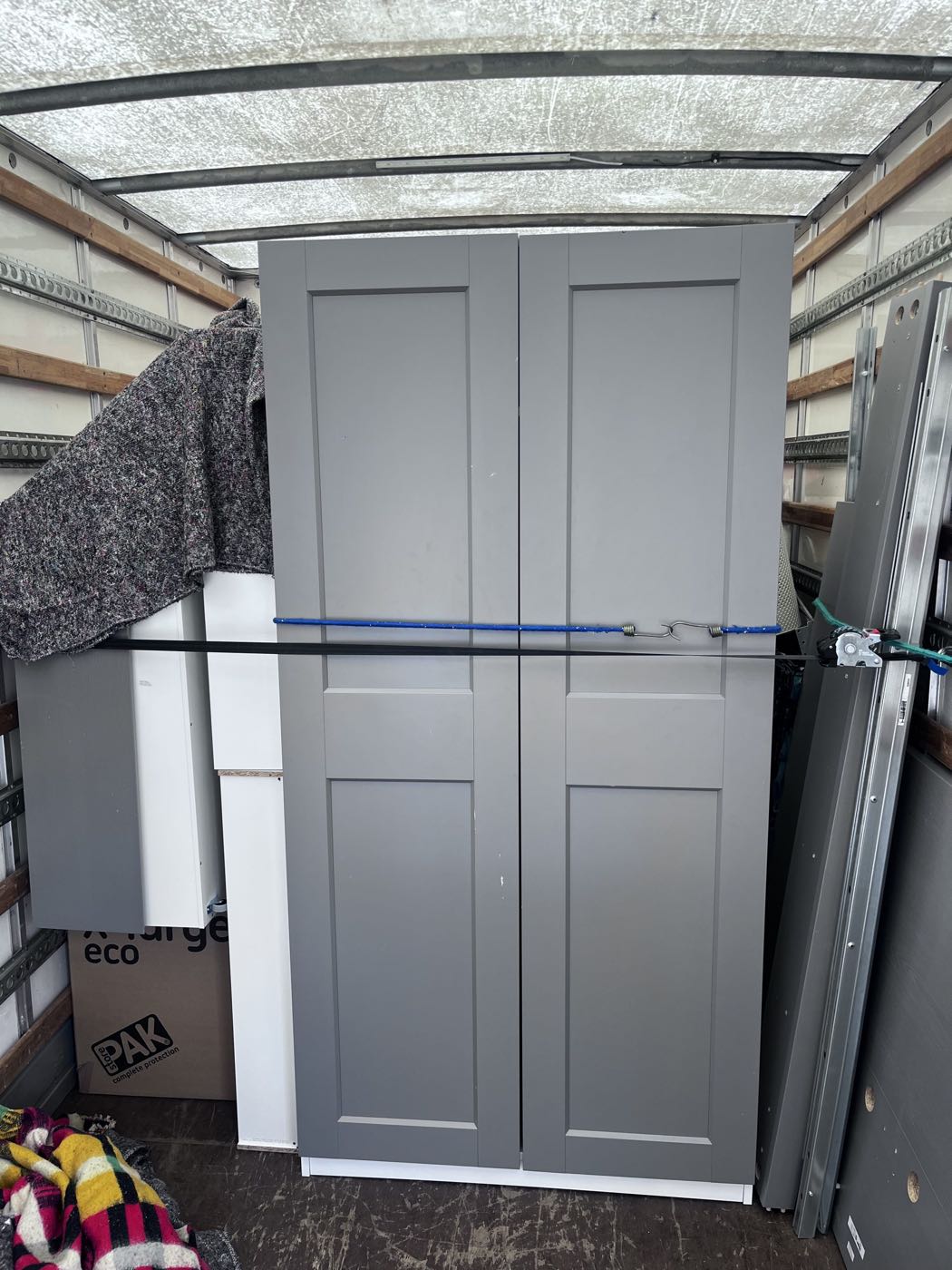 A wardrobe wrapped in blankets and strapped inside the removals van